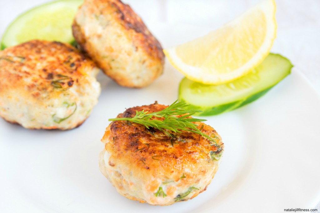 Homemade fish cakes with dill and lemon on white plate